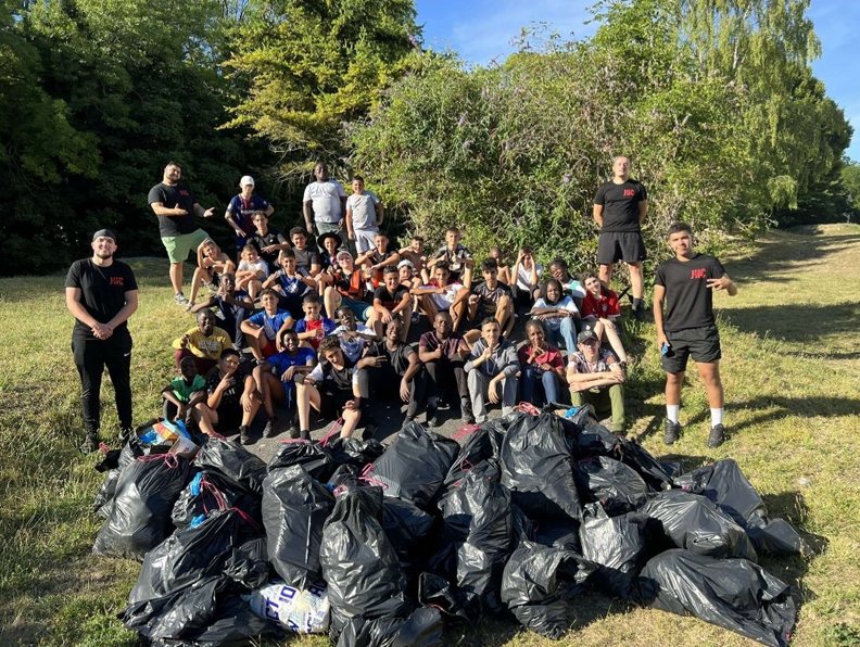 Les jeunes de l’association posent dans un parc devant les nombreux sacs de déchets ramassés pendant une action de nettoyage